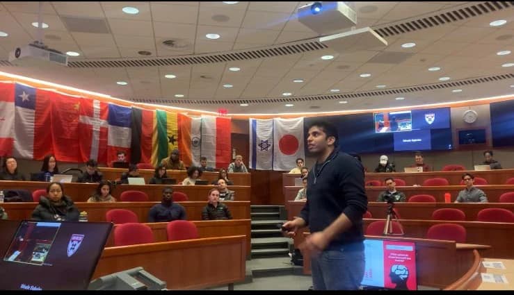 Hassan Akram presenting to an audience in a Harvard Business School case-method classroom.